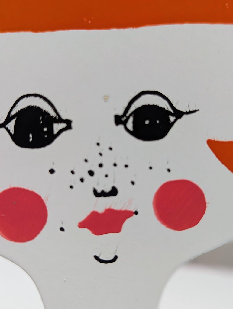Vintage Japanese steel bookend, close-up of hand-painted face with red cheeks