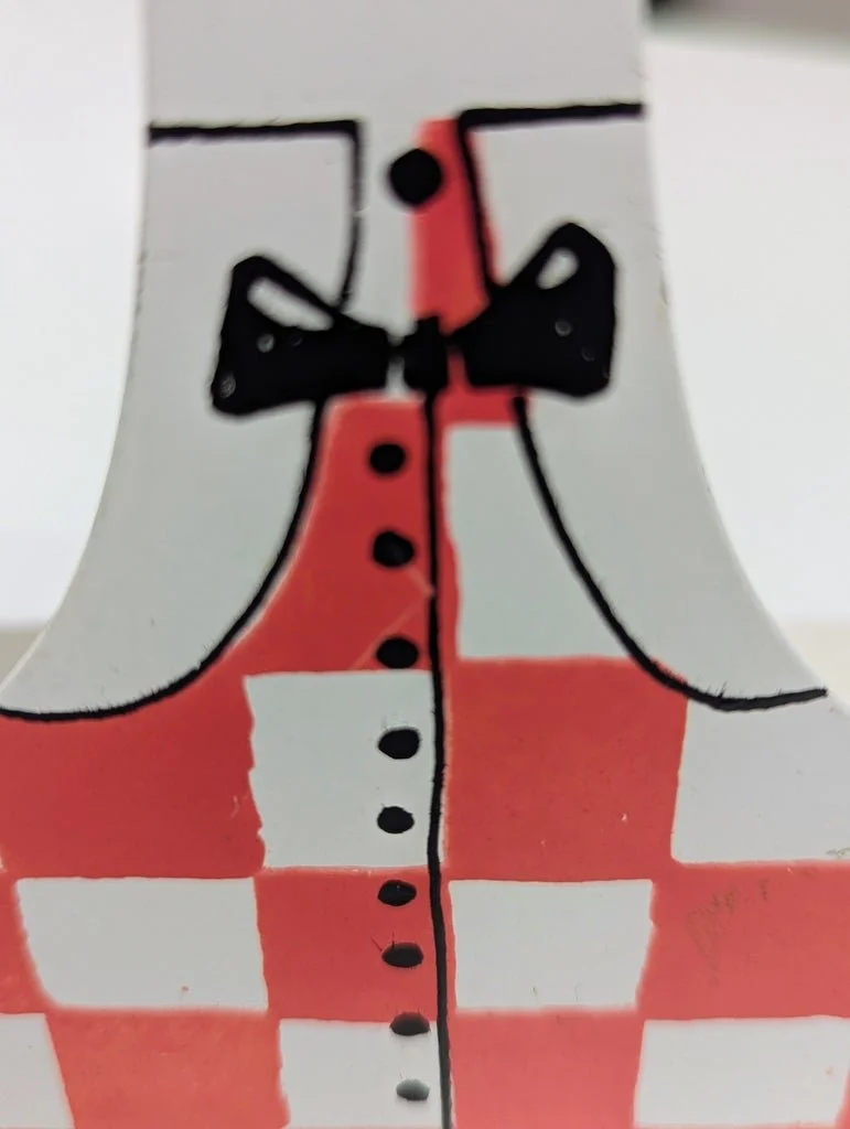 Vintage painted steel bookend, detail of checkered dress and bow
