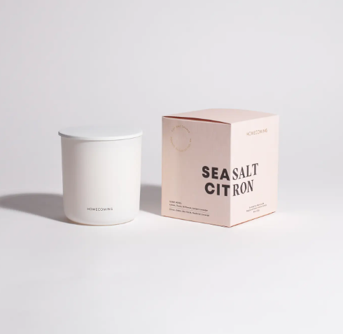 Refresh your space with the Homecoming Sea Salt Citron Soy Wax Candle, elegantly presented in its minimalist vessel and pink gift box, embodying coastal freshness.