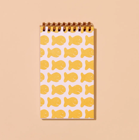A fun and nostalgic spiral notebook with a letterpress printed cover featuring a goldish cracker design.
