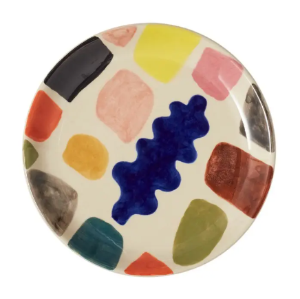 A round stoneware side plate featuring a hand-painted abstract design of colorful brushstrokes and dabs on an off-white background.
