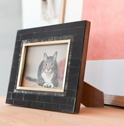 Display a favorite photo on a tabletop with the versatile Andhera Black Picture Frame by Matr Boomie Fair Trade, shown with its sturdy easel back.