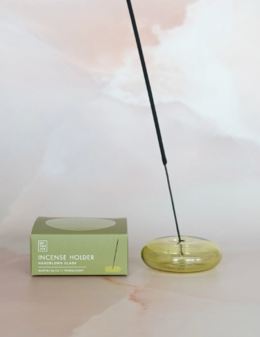 A handblown Martini Olive Translucent glass bubble incense holder by BOTANICA with a minimalist spherical design.