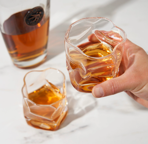 The set of two Viski Japanese Inspired Crystal Molten Tumblers filled with amber liquid.