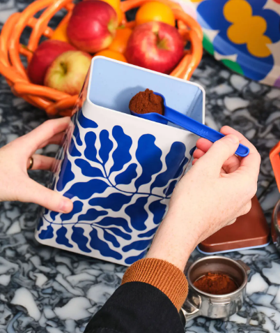 A stylish 500g metal storage tin for coffee and tea with a vibrant botanical print for kitchen shelves.