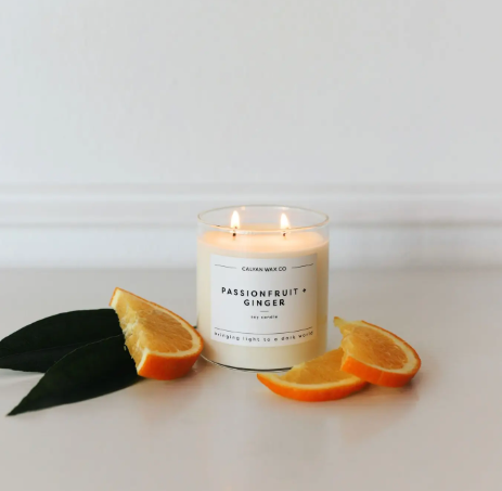 The Passionfruit + Ginger soy candle, beautifully lit and creating a warm, inviting glow with a tropical-inspired scent.