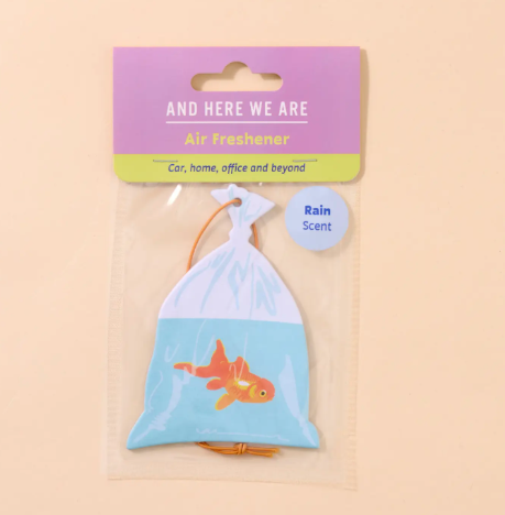 A goldfish in a bag air freshener by And Here We Are featuring a refreshing rain scent and orange hanging cord.