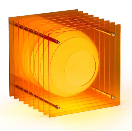 The LớP Small Square Light by BANG in a vibrant orange hue, illuminating a layered sphere illusion.