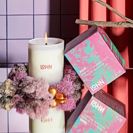 Experience the warm glow of the LOHN Erde Amber & Vetiver Candle, its flame casting a comforting light, perfect for creating an inviting and grounding ambiance.