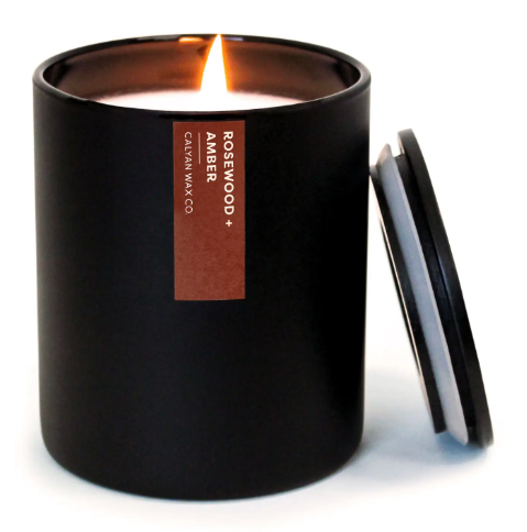 The elegant Rosewood + Amber candle with a modern matte black tumbler and a matching wooden lid, highlighting its clean design and premium feel.