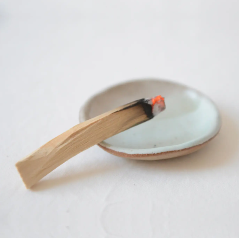 A smoking Palo Santo stick, creating a peaceful and cleansing ritual.