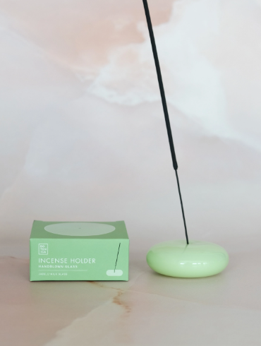 The BOTANICA Jade Milk Glass incense holder showing its soft, opaque green finish and hand-crafted shape.
