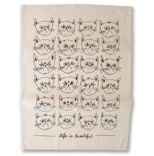 A 100% cotton tea towel featuring a grid of displeased cat faces and the ironic text "life is beautiful".