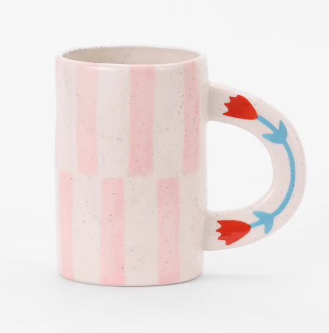 A chic pink striped coffee mug with a contrasting floral handle, handmade and high-fired for durability.