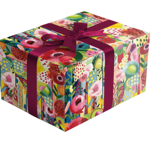 A present wrapped in Jillson & Roberts' Floral Cottage gift wrap, featuring a vibrant collage of flowers.