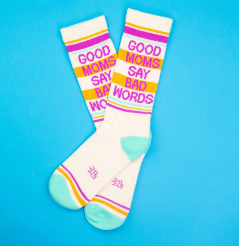 Close up of retro-style athletic socks featuring a mint green contrast toe and heel with a bold block-letter "GOOD MOMS SAY BAD WORDS" statement.