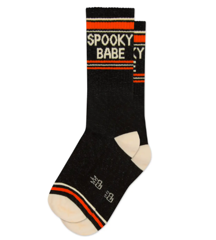 A pair of black Spooky Babe gym crew socks by Gumball Poodle showcasing their thick weave, contrasting cream heels and toes, and playful graphic text.
