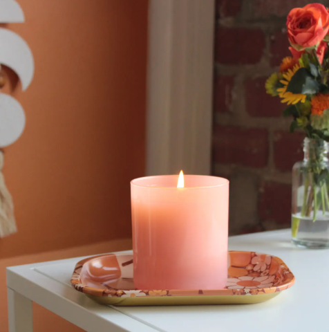 Hand-poured citrus-scented soy candle in coral glass, featuring notes of grapefruit zest and sugared orange.