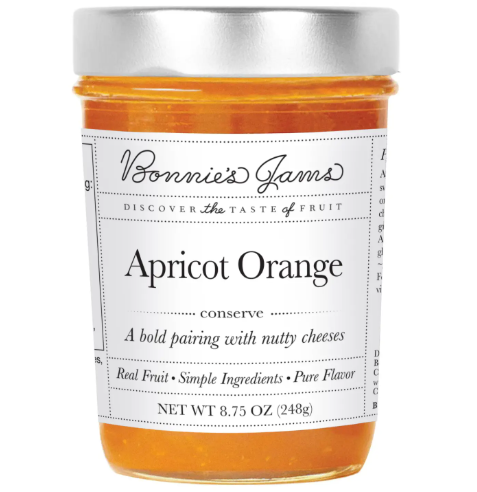 A glass jar of Apricot Orange Jam by Bonnie's Jams with a white label, showcasing the rich color and homemade feel of the product.