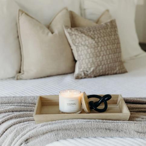 Enjoy a cozy, winter-inspired atmosphere with the lit Evergreen + Eucalyptus 3-wick candle by Calyan Wax Co. presented on a wooden bed tray.