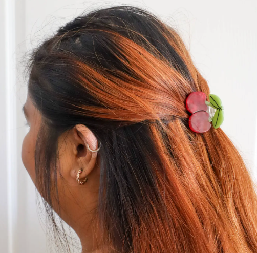A close-up of a model with the Jenny Lemons Mini Maraschino Cherries Hair Claw, emphasizing its charming scale and how it beautifully complements various hair colors and styles.