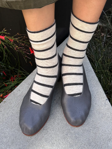Step out with Parisian flair in the Breton Stripe Wally Socks by Le Bon Shoppe, paired with chic grey flats.