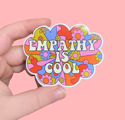 The Peach Fuzz's "Empathy Is Cool" sticker, showcasing its groovy floral design and bold message.