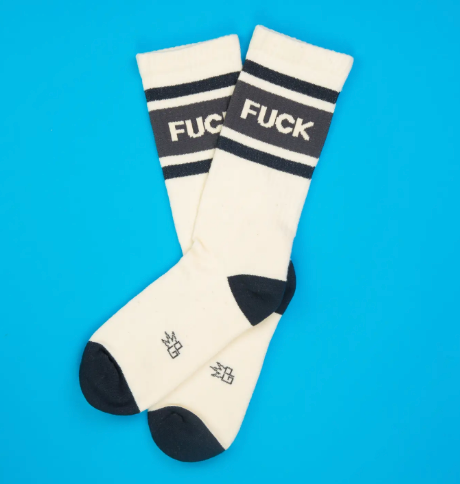 Close up of retro-style athletic socks featuring a black contrast toe and heel with a bold block-letter statement.