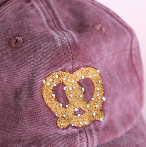 A close-up view highlighting the detailed golden embroidery and white salt flakes of the pretzel design.