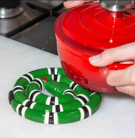 Protect your kitchen counters with the Snake Trivet by DOIY, a bold and unexpected ceramic hot pad featuring a glossy, colorful coiled serpent design.