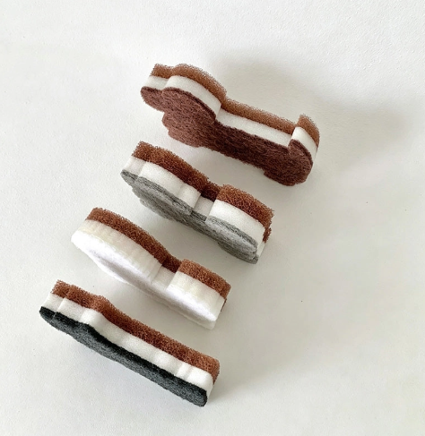Highlight the durable three-layer composite construction of the CouldNook Dog-Shaped Dish Sponges arranged in a row.