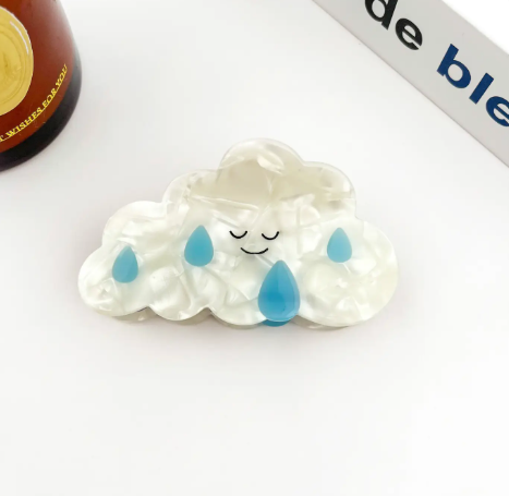 The Raindrop style Cute Cartoon Cloud Hair Clip by TheDivaSoap detailed with serene closed eyes and light blue droplet details.