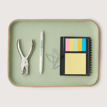 A large Aloe green Kawabon tray featuring a sculpted Vachetta leather base and a soft Merino wool interior lining.