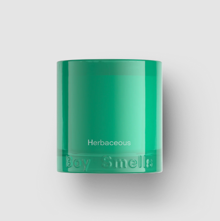 The Boy Smells Herbaceous candle in its green glass vessel, displaying the "Herbaceous" label.