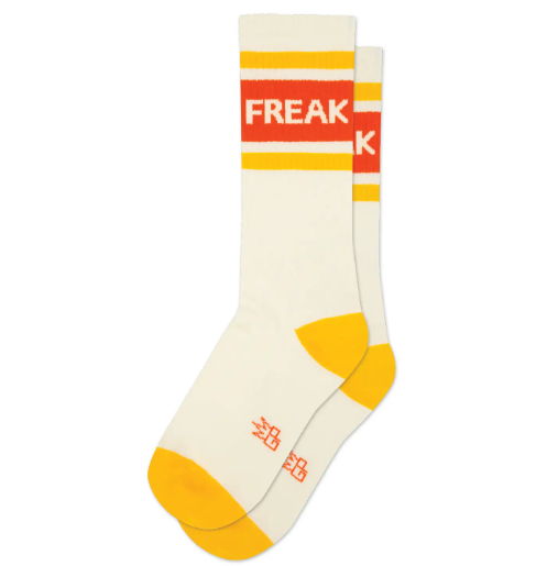 Make a statement with Gumball Poodle's "FREAK" Gym Crew Socks, featuring bold orange lettering and gold accents on a cream background, showcasing their unique design.