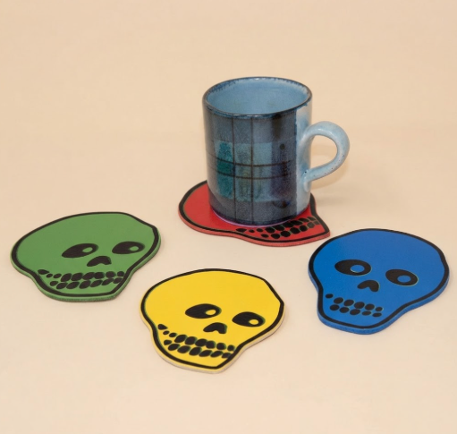 Protect your surfaces in style with this unique set of leather coasters from Ark Colour Design, showcasing hand-drawn skull faces in a bold, contemporary color palette.