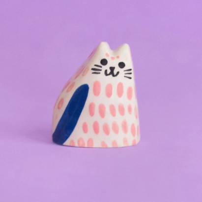 The Ana Seixas Baby Cat in vibrant pink, showcasing its glossy finish, intricate hand-painted details, and whimsical design.