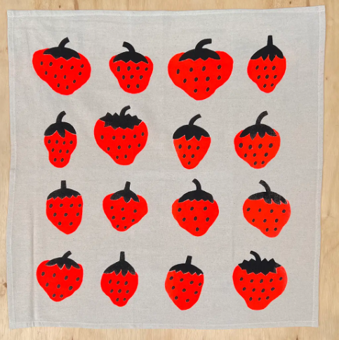 A beautiful hand-printed cotton tea towel with a vibrant strawberry design, perfect for adding a pop of color to your kitchen.