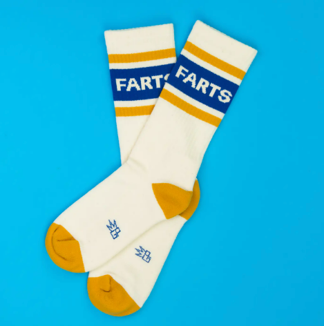 A pair of white gym-style socks with humorous text, proudly made in the United States with a cotton blend.