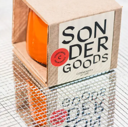 A minimalist Sonder Goods soy candle in an amber glass jar, featuring a destination-inspired scent like Connemara.