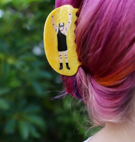 The Trash Man Claw Clip by Boogie Bee securing a person's vibrant pink updo, showing how the clip adds a bold, humorous accent to the hair.