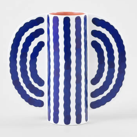 A modern blue and white striped vase with a distinctive butterfly-like silhouette.