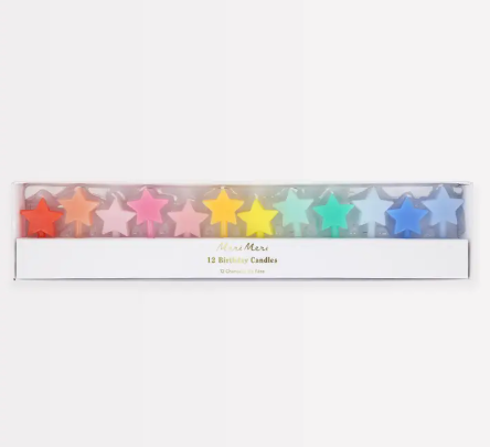 A sleek, clear-windowed box displaying a vibrant rainbow spectrum of twelve star-shaped birthday candles by Meri Meri.