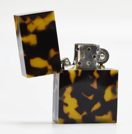 A modern, refillable pocket lighter in a tortoise finish, perfect for an everyday carry collection.