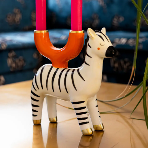 Glossy glazed ceramic zebra decor piece designed to hold two dinner candles for a striking and adventurous look.