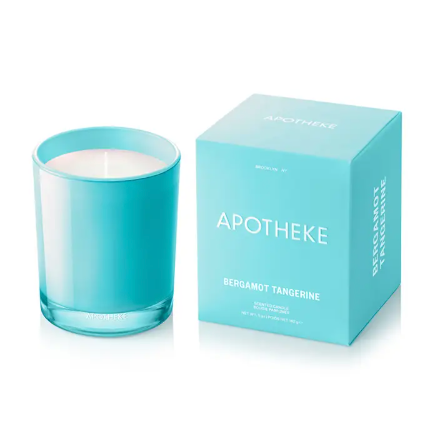 The APOTHEKE Bergamot Tangerine candle and its packaging, highlighting the vibrant turquoise color of both the glass vessel and the minimalist box design.