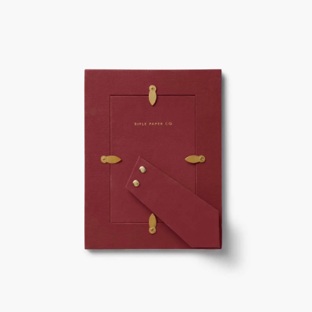 The back of the Delphine paper-wrapped picture frame showing the sturdy kickstand and gold-toned hardware.