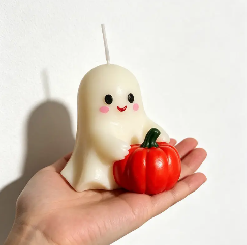Showcase your playful holiday spirit with the Ghost Pumpkin Candle Style 1 by CouldNook, cradling a bright red pumpkin in hand.