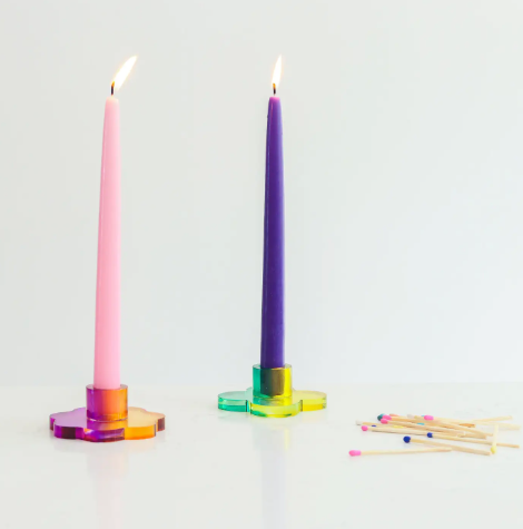 The Daisy and Nimbus Duotone Acrylic Candlestick Holders displaying pink and purple taper candles.