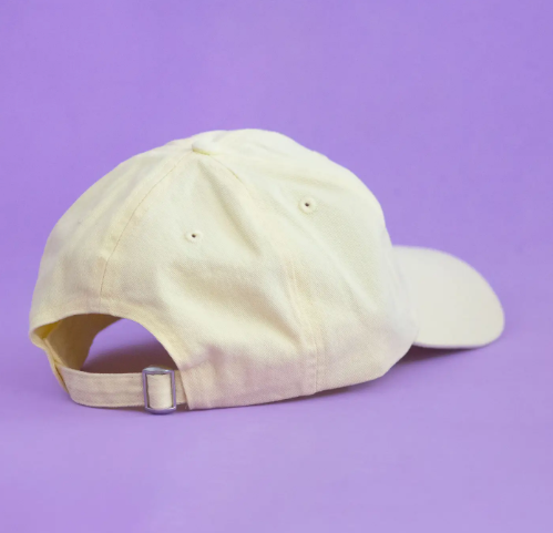 The back of the Ana Seixas Magic Lemon Cap, showcasing its light yellow cotton fabric and the adjustable fabric strap with a metal clasp for sizing.